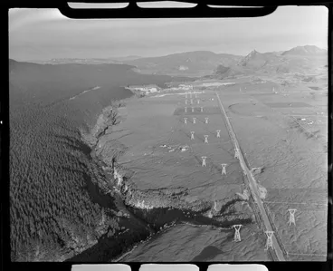 Image: Waikato River near Whakamaru, Waikato Region, including pine forest, power pylons, and Whakamaru hydro-electric power station under construction in the distance