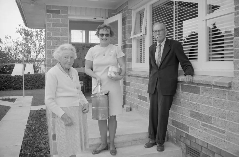 Meals on Wheels woman delivering food to a couple