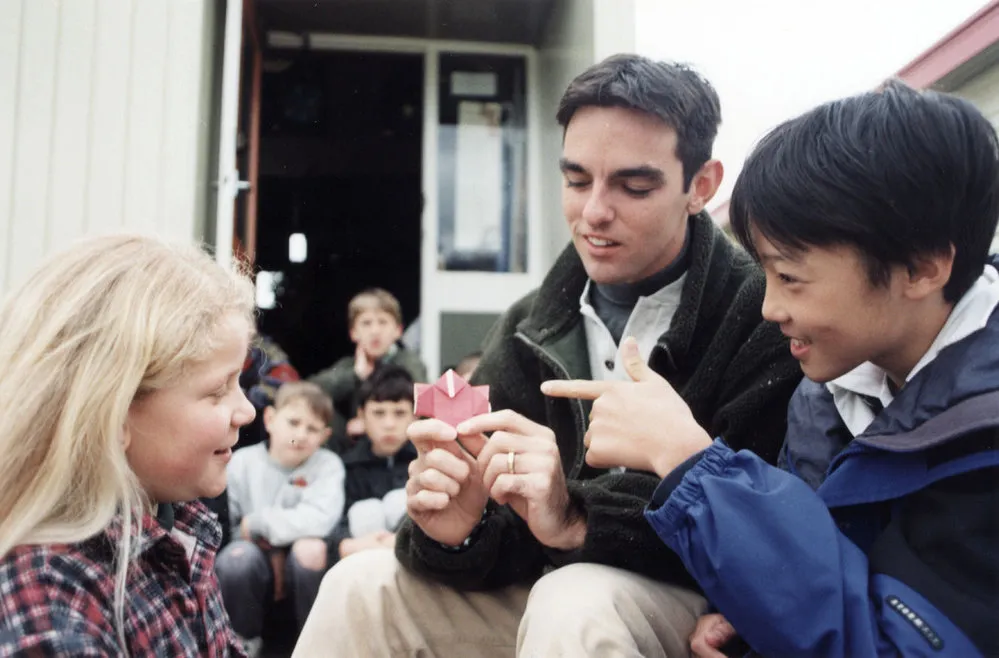 Trentham School; visitor Yoshihiro Goto shows Kathleen Merrett a piece of origami.
