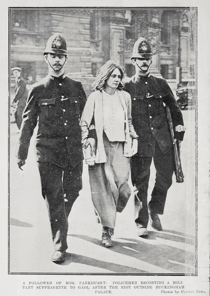 Policemen escorting a militant suffragette and follower of Mrs Pankhurst to gaol