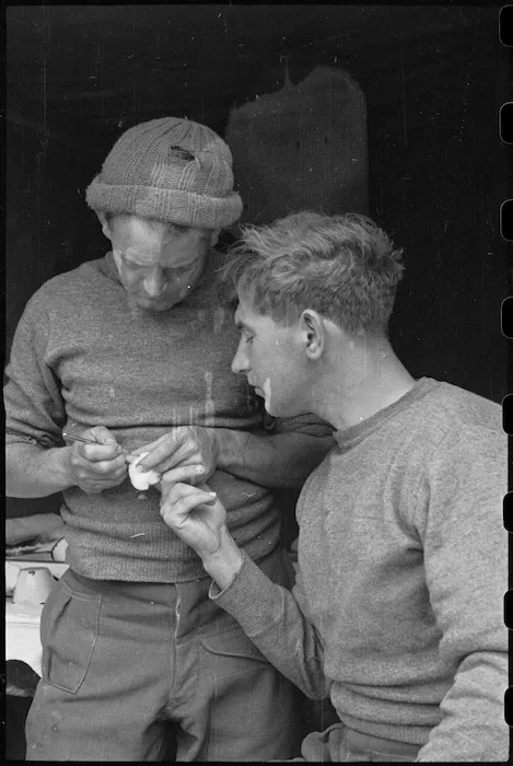C Purchase dresses a slight cut for L W Feathery at Regimental Aid Post truck in Divisional HQ area, Casale, Italy, World War II - Photograph taken by George Bull