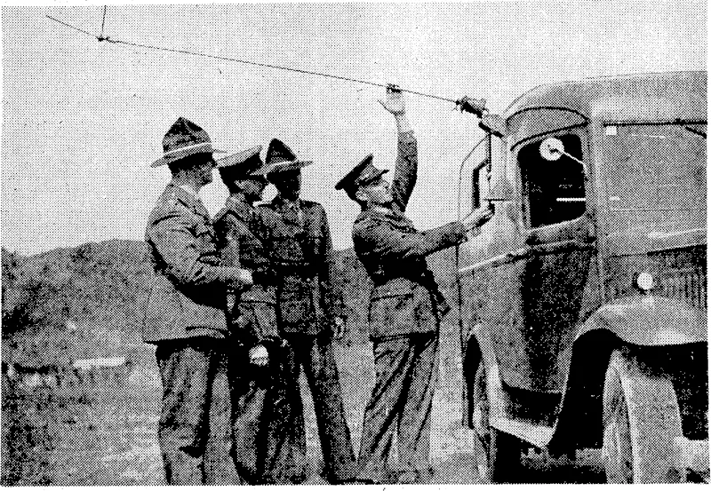 Evening Post" Photo, A general view of the telegraph operating room at the Wellington General Post Office, through ivhich the messages relating to the progress of the General Election will pass on Saturday evening to the Chief Electoral Officer, and thence to the results board in front of the "Evening Post" building. A new aerial base fitting for the, army wireless vans, exhibited recently at Trentham Camp. Major E. H. R.Green, Assistant Director of Signals, Captain G. F. Heal, Staff Officer Signals, and Lieutenant E. V. Harwood, Adjutant Central Depot New Zealand Corps of Signals, are seen inspecting the new fitting. (Evening Post, 12 October 1938)