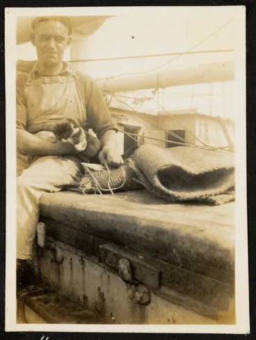 Unidentified man, labelled as the Bosun, holds a cat on deck of unidentified ship. Image: Unidentified man, labelled as the Bosun, holds a cat on deck of unidentified ship.