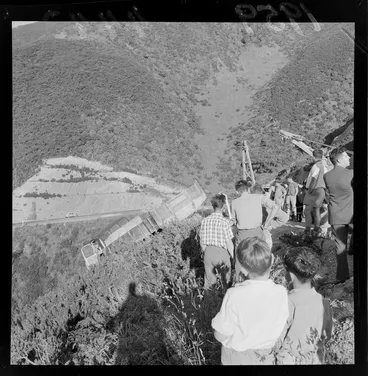 Image: Group of unidentified people at the site of an accident on Wainuiomata Hill Road, showing a truck that has come off the road