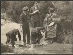Charles Kingsford Smith, H.A. Litchfield and guide Bella, with T.H. McWilliam and Charles Ulm testing water temperature of hot pools, at Rotorua, New Zealand, September 1928 / J.F. Louden