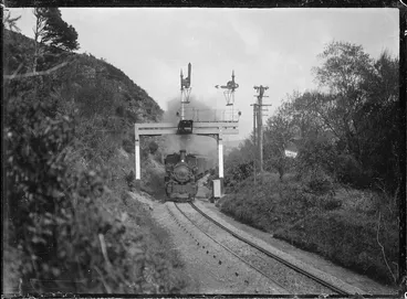 Image: "Ww" class steam locomotive passing automatic three position electric signals in the Silverstream Gorge.