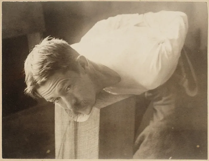 Man with his head on chopping block