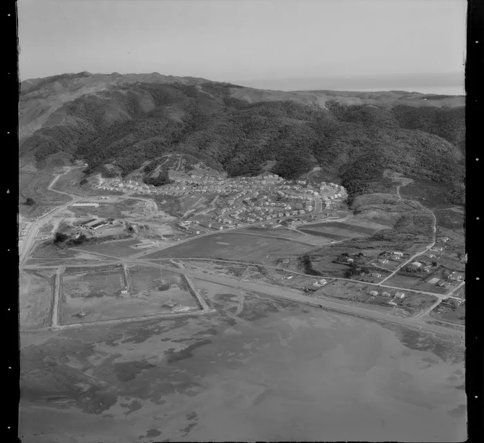 View of the Porirua suburb of Takapuwahia with Porirua Harbour and Titahi Bay Road in foreground with Elsdon Park to scrub covered hills beyond, Porirua District, Wellington Region
