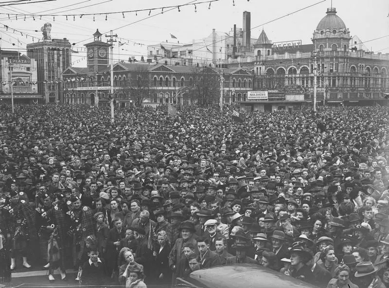 Celebrations. Crowd at WWII, Victory over Europe ( VE ) Day Celebration. Held 9 May 1945, Pipe Bandsman front Left. Cathedral Square, Christchurch, Canterbury, New Zealand.