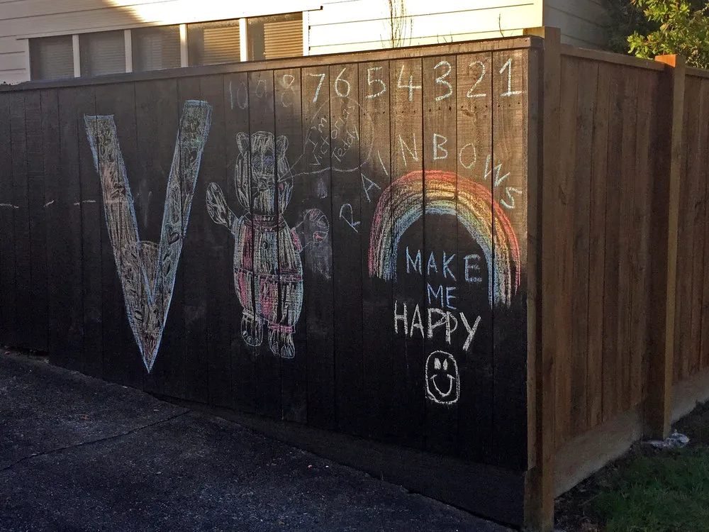 Child's chalk drawings on fence, Heretaunga