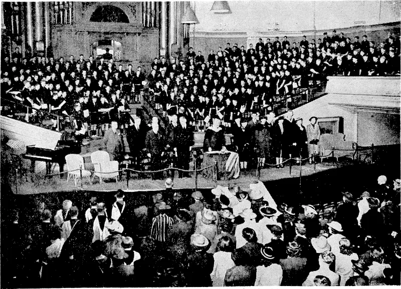 Evening Post" Photo. Scenes in the Town Hall this morning when the Correspondence Schools field/ a – "break-up" ceremony, at which Sir Harry Batterhee, High Commissioner for the United Kingdom in New Zealand, was the chief speaker. The principal of the schools, Dr. A. G. Butchers, who is seen at the table wearing his gown, presided over,the gathering, and the Rongotai College choir (seated in the background) gave several -■■■■■■■ song items. (Evening Post, 14 December 1939)