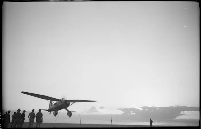 RAF machine flying low to pick up messages strung between uprights