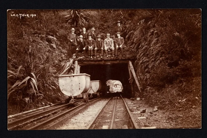 Group of nine men above entrance to Otira Tunnel.