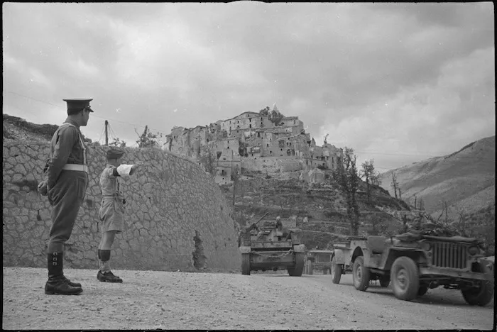 New Zealand provost, J J Morgan, directs traffic at turnoff near Aquafondata, Italy, World War II - Photograph taken by George Bull