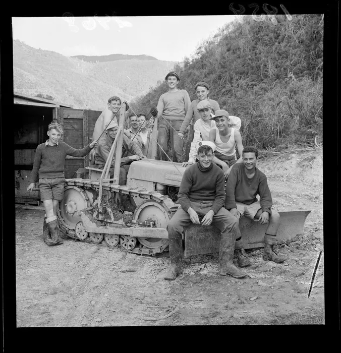 Group of unidentified boys sitting on a bulldozer during a Boys Brigade camp in Wainuiomata, Wellington.