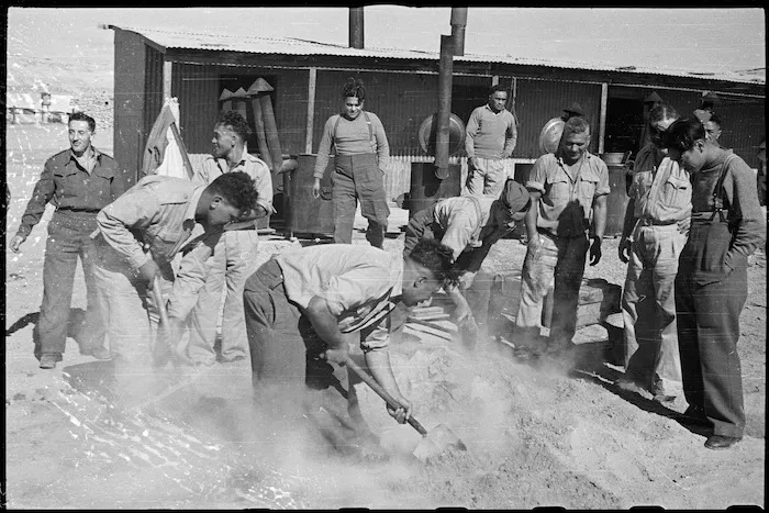 Uncovering the Christmas hangi at the Maori Training Depot, Maadi Camp, Egypt - Photograph taken by George Bull