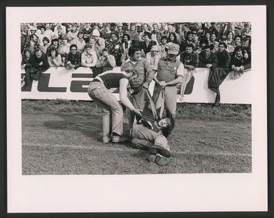 Rugby supporters hand a demonstrator off the Field, Hamilton.