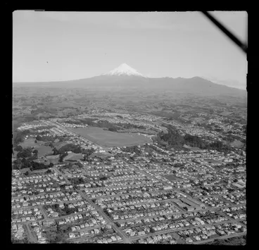 Image: View over New Plymouth, Taranaki District, showing the racecourse with Eliot Street into Coronation Avenue (State Highway 3) and Pukekura Park, to farmland and the Pouakai Range with Mount Taranaki beyond