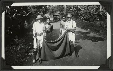 Image: Sailors removing the white band, the insignia of the Mau, from lava lavas