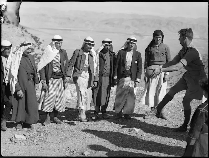 Member of NZ Divisional Cavalry demonstrates football to Syrian tribesmen, World War II - Photograph taken by H Paton