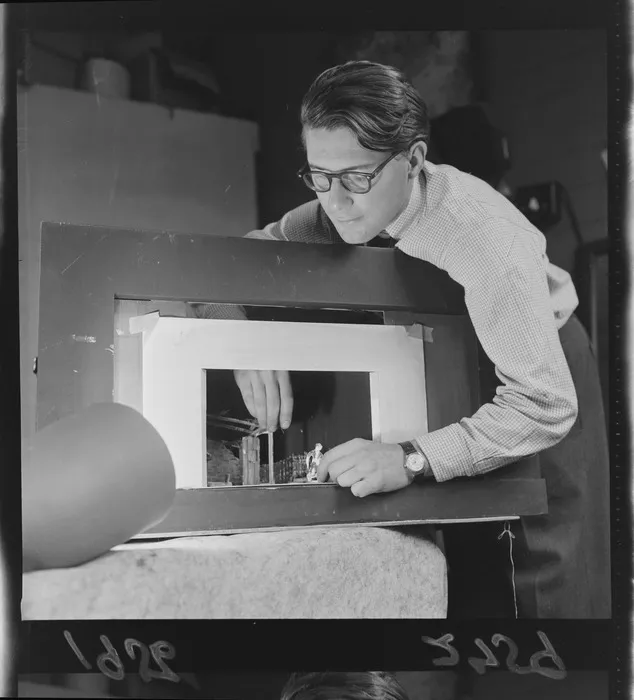 Raymond Boyce, set designer for the New Zealand Players, with a miniature model of a stage and set