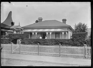 Image: Laura Godber with her two children, Phyllis Mary and William Albert, standing on the verandah of their house, Railway Whare, at 23 Bay Street, Petone