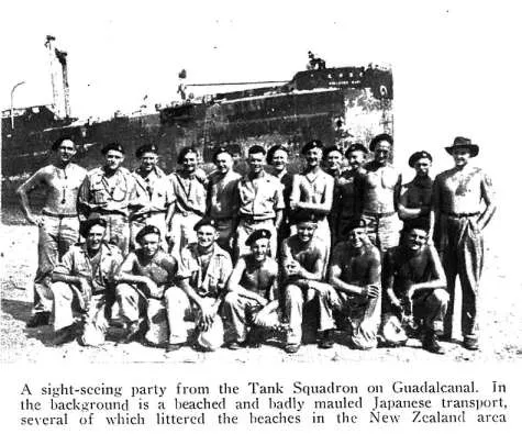 A sight seeing party from the Tank Squadron on Guadalcanal In the background is a beached and badly mauled Japanese transport, several of which littered the beaches in the New Zealand area