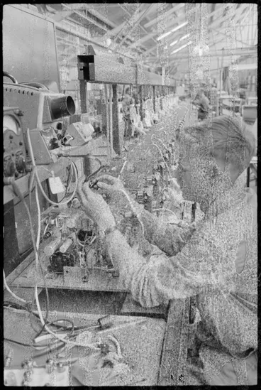 Image: TISCO. A technician watching a dial while he winds on the coil for T.V. receiver