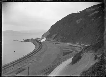 Image: View of a train rounding Rocky Point in 1908 after the track was moved nearer the harbour following partial reclamation, between Wellington and Petone.