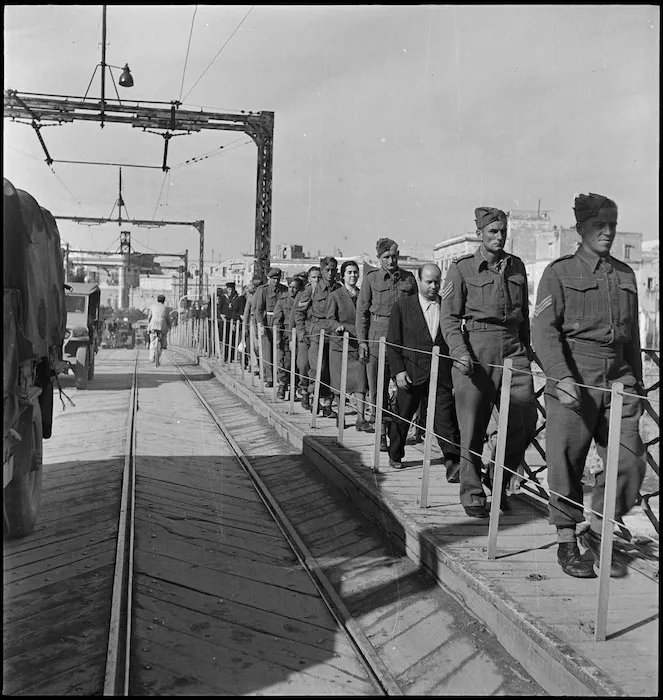 NZ soldiers walking single file across the swing bridge in Taranto, Italy, World War II