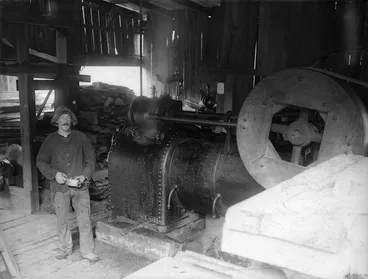 Image: Man standing beside machinery in a timber mill, Akatarawa