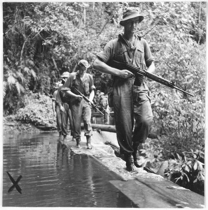 Privates T Farley and R A Smith crossing the top of a dam, Malaya