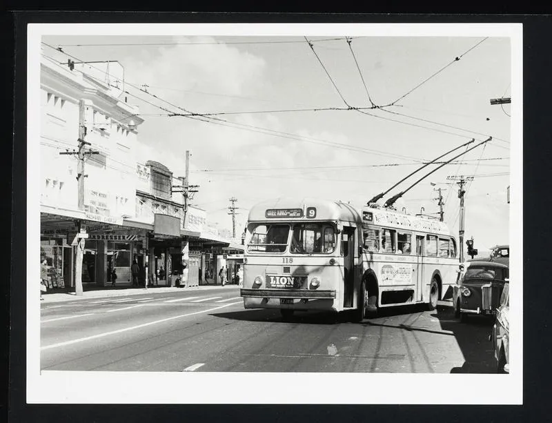 Trolley bus 118 on route 9 Three Kings turning onto road with shops