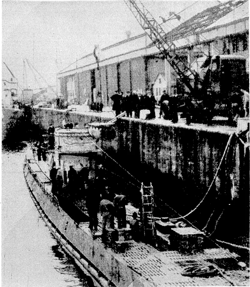 British Official PhotoÂ—VlA BEAM WIRELESS. The cargo of a blockade-running U-boat being unloaded in Gladstone Dock, Liverpool, England, after surrender in the Atlantic. The cargo was being brought to Germany from Japan hidden in the upper casing of the submarine. (Evening Post, 24 May 1945)
